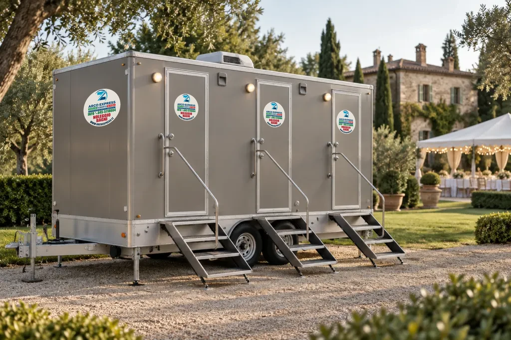 Rimorchio di bagni mobili con tre ingressi e scalette nel giardino di una villa allestita per un ricevimento